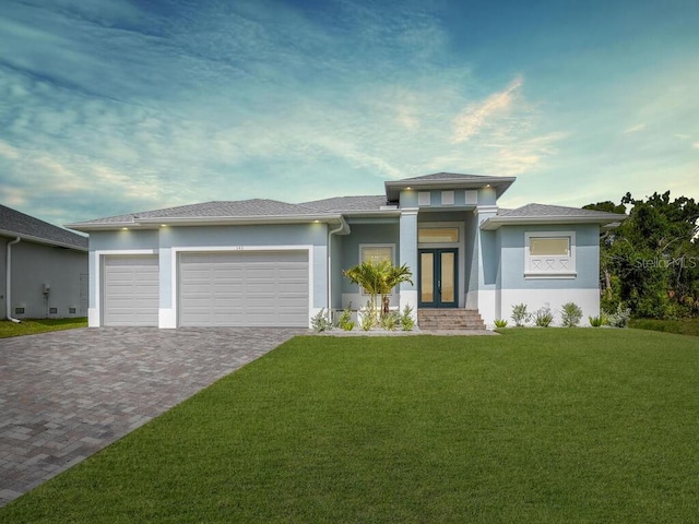 prairie-style home featuring a garage and a front lawn