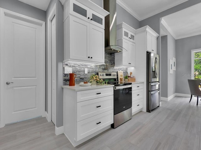 kitchen with ornamental molding, backsplash, white cabinets, appliances with stainless steel finishes, and wall chimney range hood