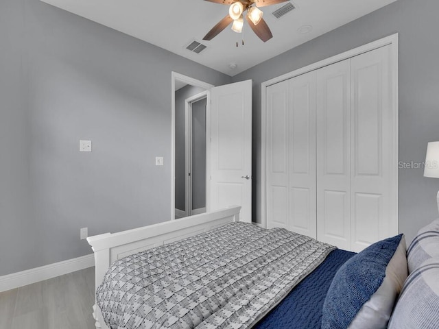 bedroom with hardwood / wood-style flooring, ceiling fan, and a closet