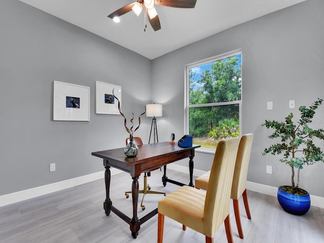 home office with light wood-type flooring and ceiling fan