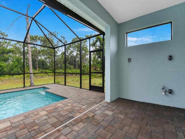 view of swimming pool with a patio and glass enclosure