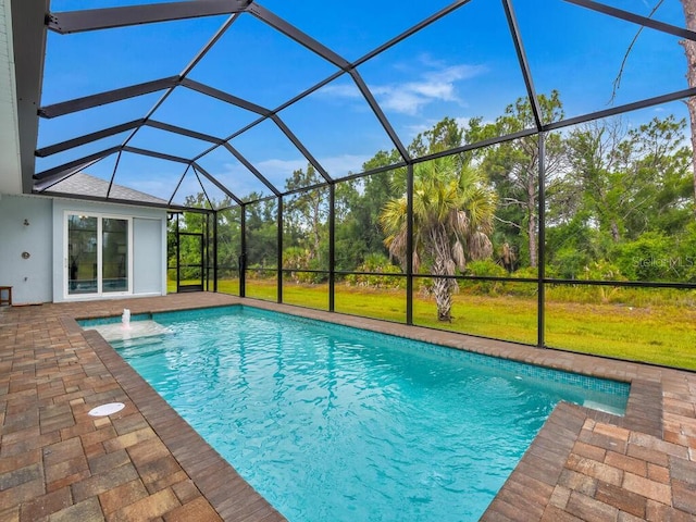 view of swimming pool with pool water feature, a patio, glass enclosure, and a lawn