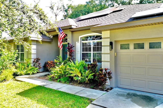 doorway to property with solar panels and a garage