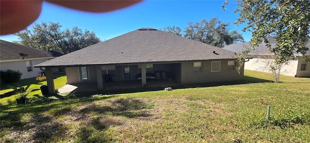 back of property with a yard and a patio