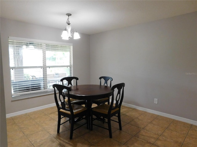 dining area with light tile patterned flooring and an inviting chandelier