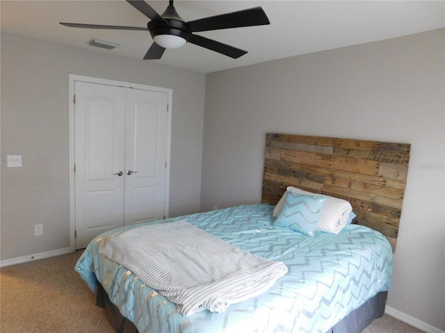 carpeted bedroom featuring ceiling fan and a closet