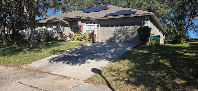 single story home with solar panels, a garage, and a front yard