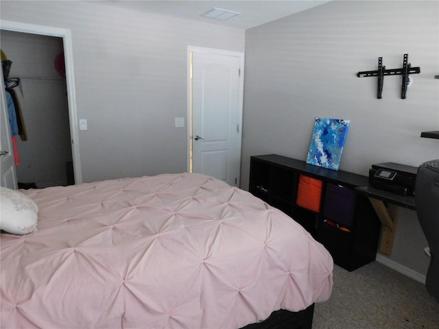 bedroom with a spacious closet, a closet, and carpet