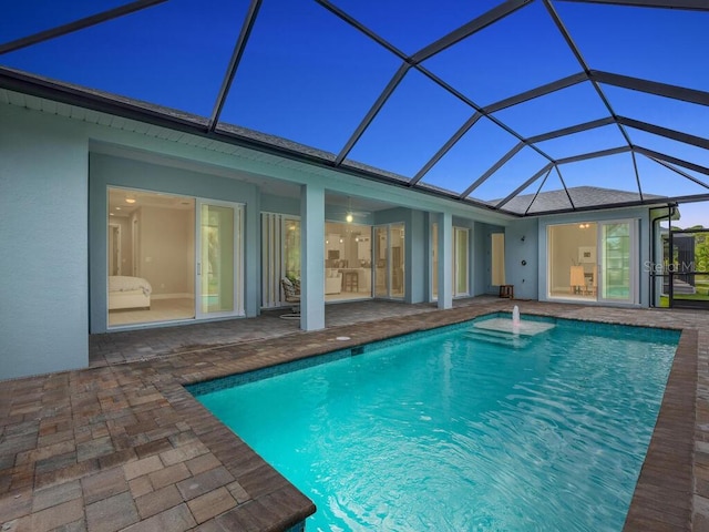 view of swimming pool with pool water feature, a lanai, and a patio area