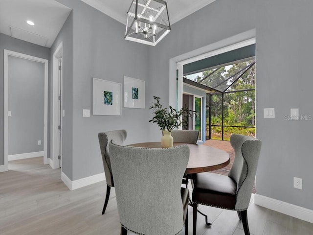 dining area with crown molding and light hardwood / wood-style floors