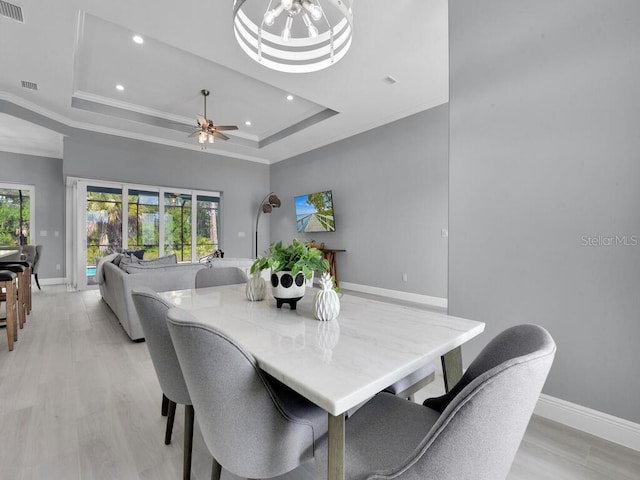 dining room with a wealth of natural light, a tray ceiling, and ornamental molding