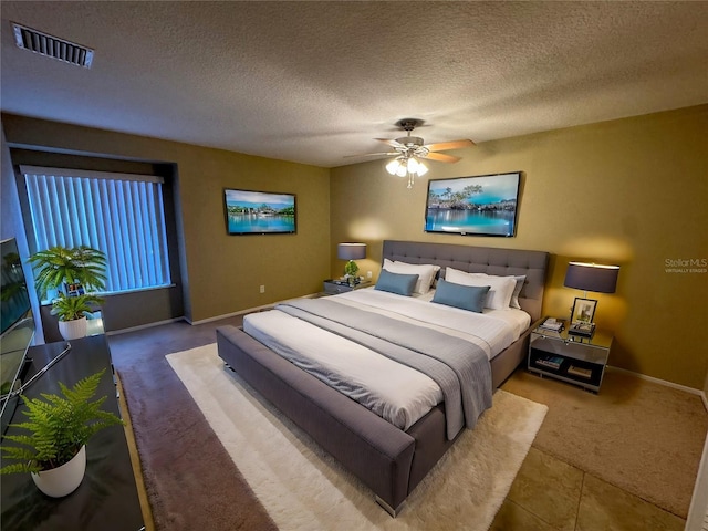 bedroom featuring ceiling fan, carpet flooring, and a textured ceiling