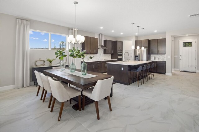 dining space with sink and a notable chandelier