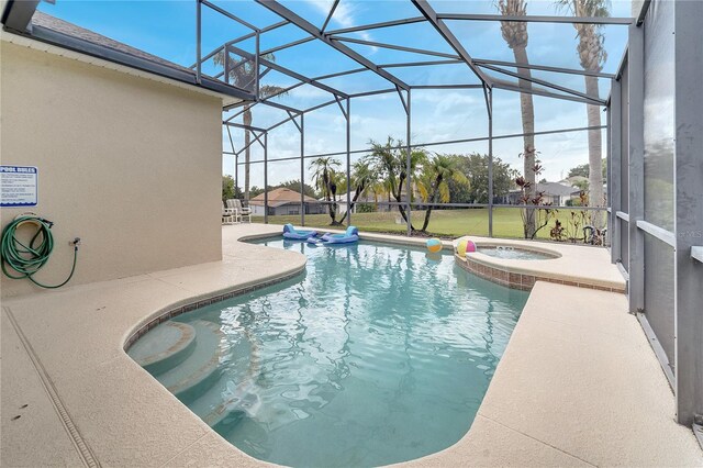 view of pool with an in ground hot tub, a patio area, and glass enclosure