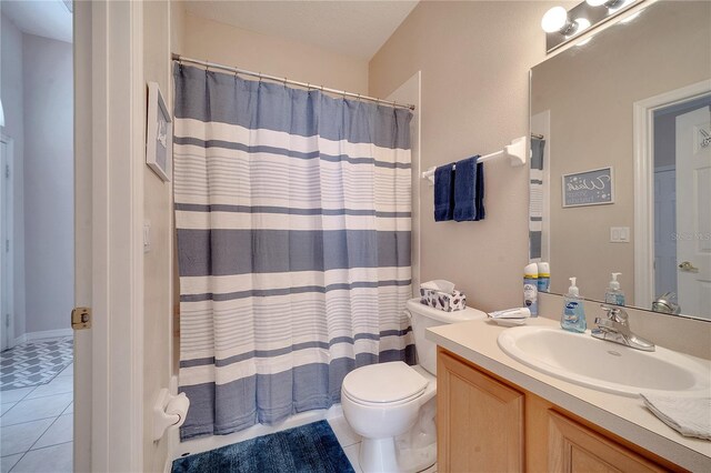 bathroom featuring tile patterned flooring, vanity, and toilet