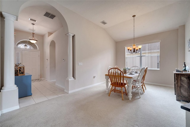 dining room with a notable chandelier, vaulted ceiling, light carpet, and ornate columns