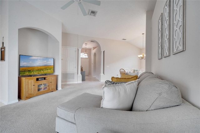 carpeted living room with lofted ceiling and ceiling fan with notable chandelier