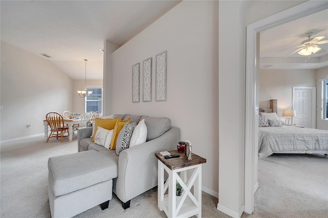 carpeted living room with vaulted ceiling and ceiling fan with notable chandelier