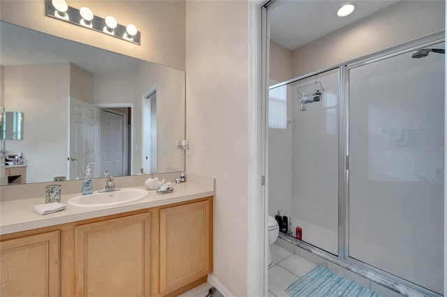 bathroom with tile patterned floors, toilet, a shower with shower door, and vanity