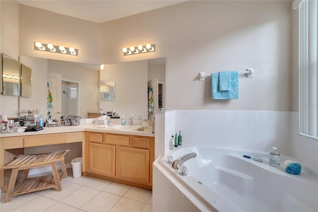 bathroom featuring tile patterned floors, vanity, and tiled tub