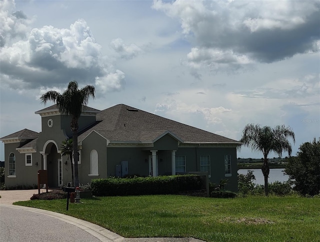 view of front facade featuring a front yard and a water view