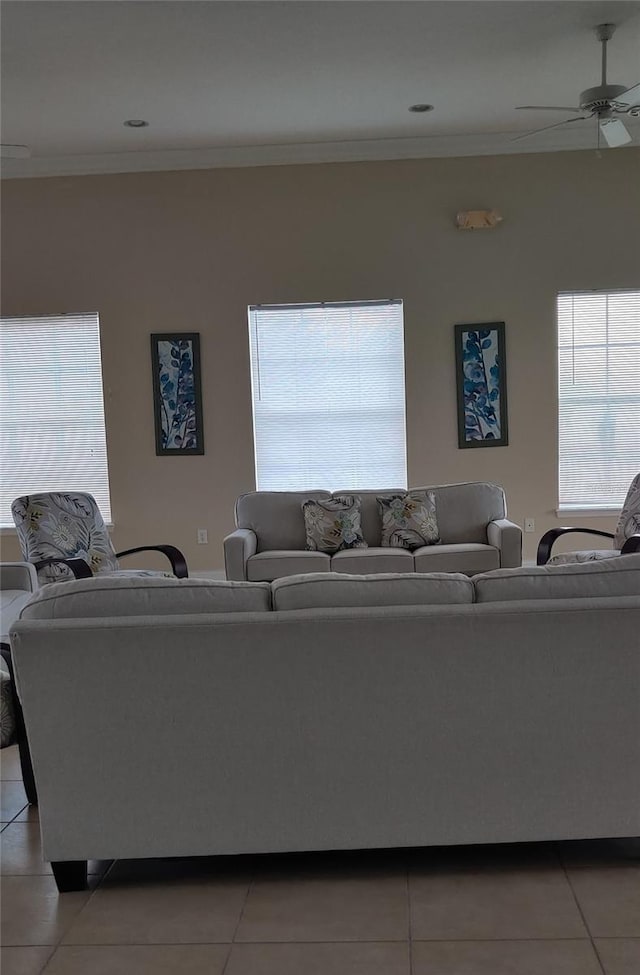 living room with crown molding, ceiling fan, and a healthy amount of sunlight