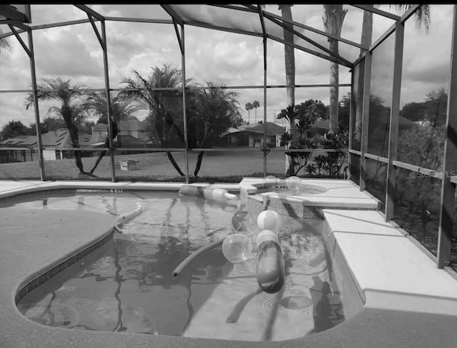 exterior space with an in ground hot tub and glass enclosure