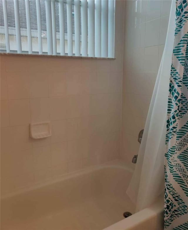 bathroom with shower / bath combo with shower curtain