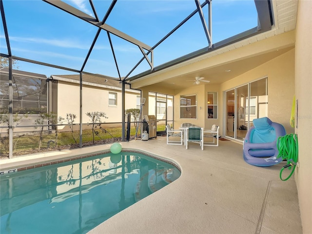 view of swimming pool featuring ceiling fan, a lanai, and a patio