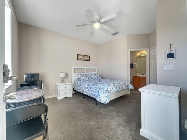 bedroom featuring ensuite bath, ceiling fan, and dark colored carpet