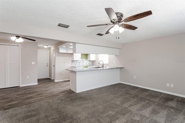 kitchen with sink, white cabinets, decorative backsplash, ceiling fan, and kitchen peninsula