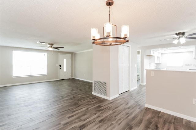 unfurnished room with dark hardwood / wood-style floors, ceiling fan with notable chandelier, and a textured ceiling