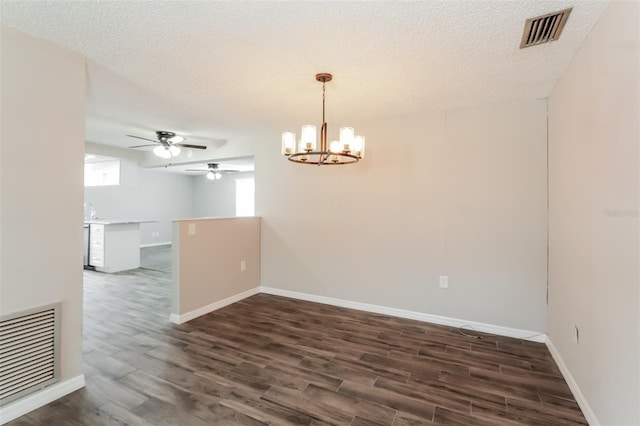 spare room with sink, ceiling fan with notable chandelier, dark hardwood / wood-style floors, and a textured ceiling