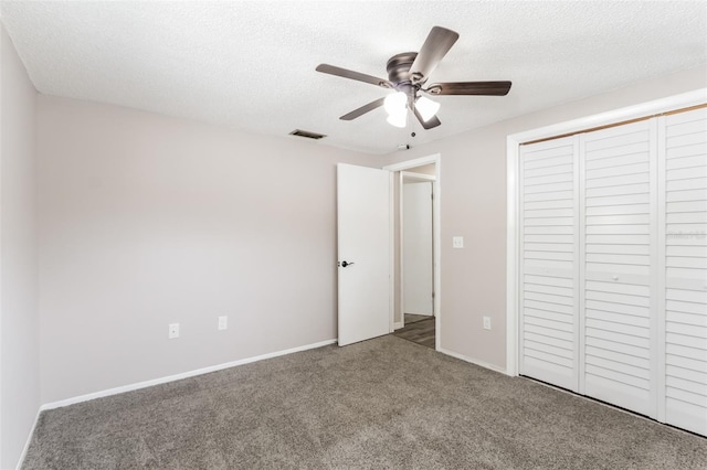 unfurnished bedroom featuring ceiling fan, a closet, carpet flooring, and a textured ceiling