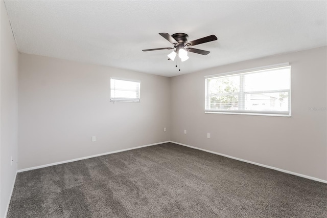 unfurnished room featuring ceiling fan and dark colored carpet