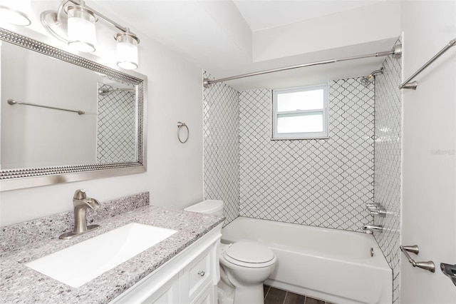 full bathroom featuring vanity, tiled shower / bath combo, and toilet