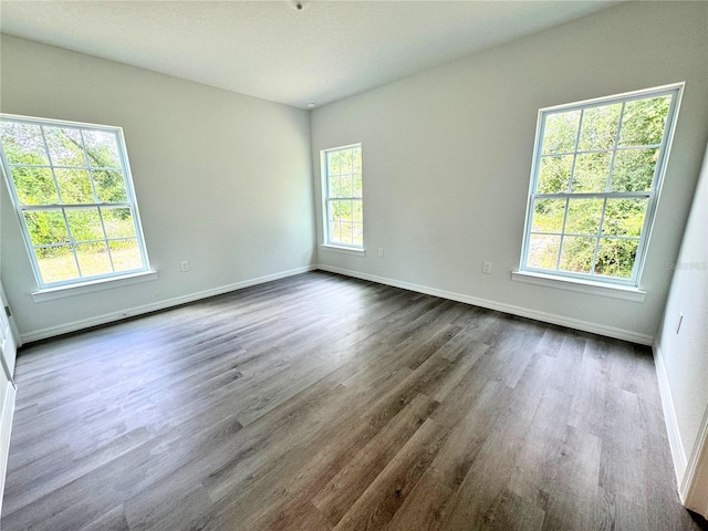 unfurnished room featuring a healthy amount of sunlight and hardwood / wood-style floors