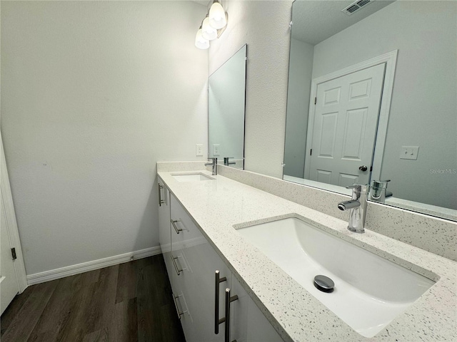 bathroom with hardwood / wood-style flooring and double vanity