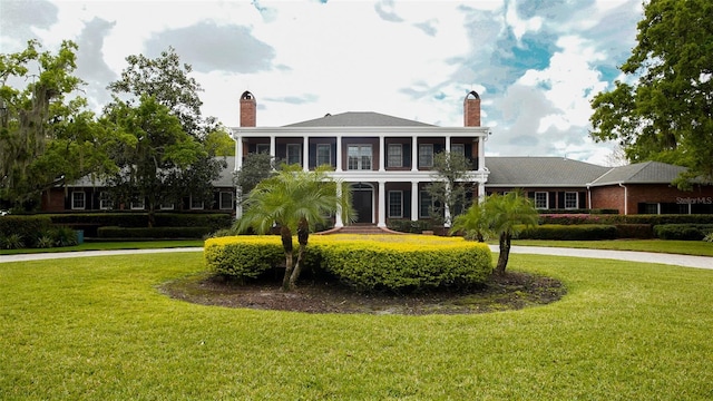 view of front facade featuring a sunroom and a front yard