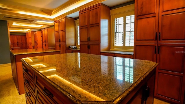 kitchen featuring dark stone counters, crown molding, and a kitchen island