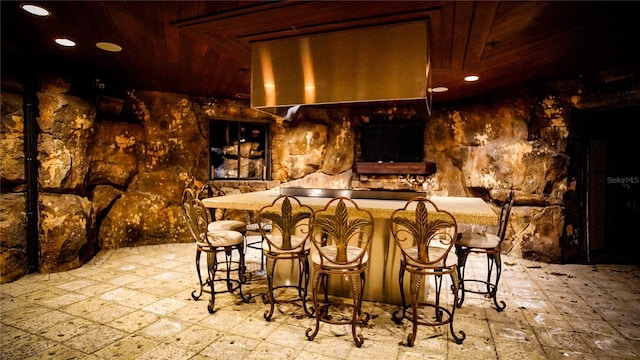 bar with wooden ceiling and light tile patterned floors