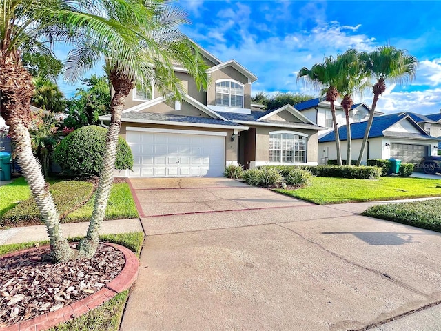 view of front of home with a garage, a front yard, driveway, and stucco siding