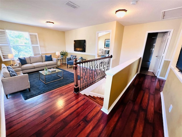 living room with baseboards, visible vents, and wood finished floors