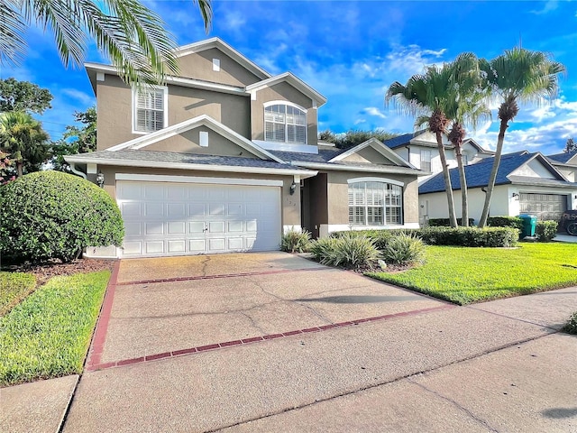 traditional home with a front yard, concrete driveway, an attached garage, and stucco siding