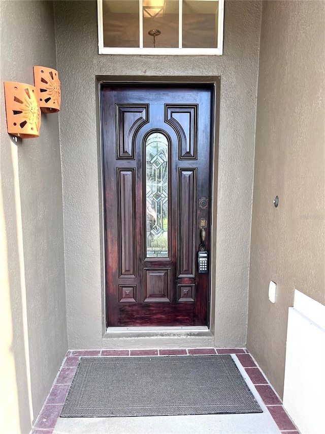 entrance to property featuring stucco siding