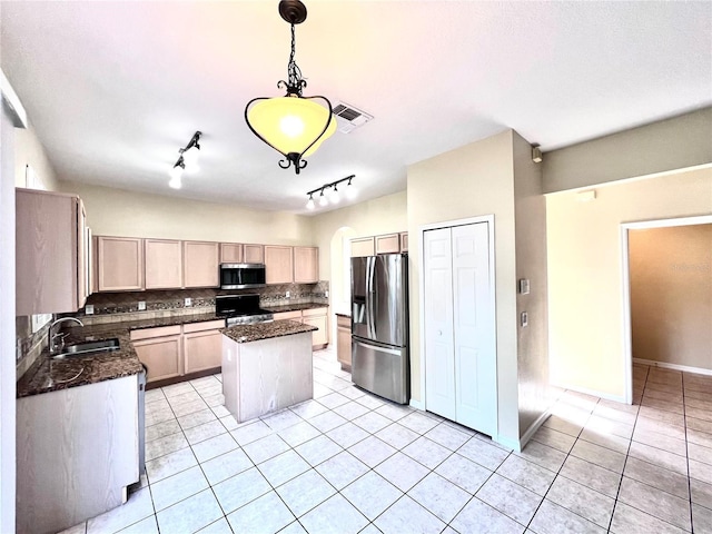 kitchen with visible vents, decorative light fixtures, a center island, stainless steel appliances, and a sink