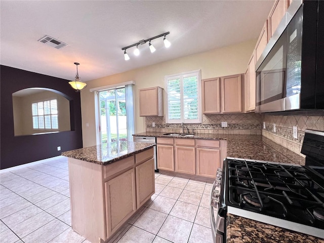 kitchen featuring appliances with stainless steel finishes, a center island, visible vents, and light brown cabinets