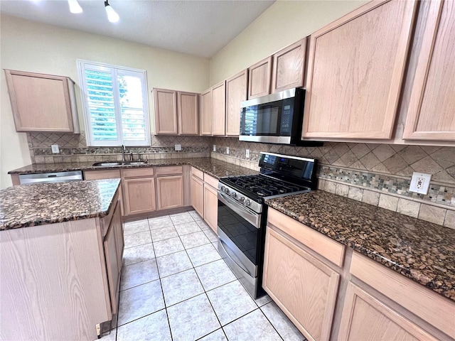 kitchen featuring light tile patterned floors, light brown cabinets, stainless steel appliances, and a sink