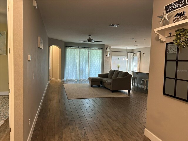 living room with dark hardwood / wood-style flooring and ceiling fan