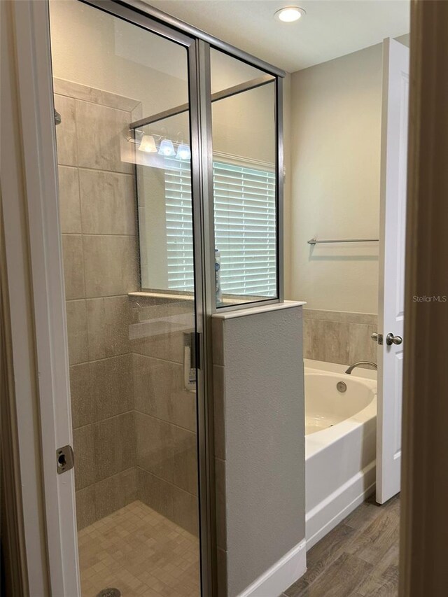 bathroom featuring shower with separate bathtub and hardwood / wood-style floors